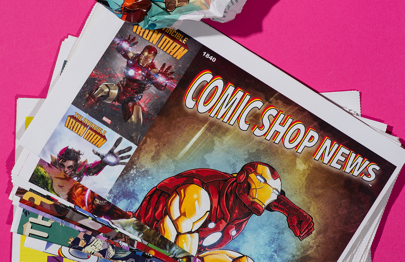 Comic Shop News issue photographed on a wooden surface